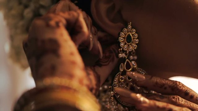 Hindu bride adjusts white flowers in her hair