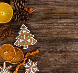 gingerbread christmas tree cookies and snowflake with decorations on wooden background