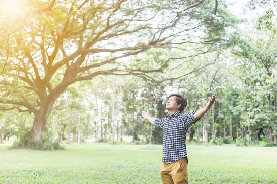 Happy Young Man with Hands Up on the Nature Background