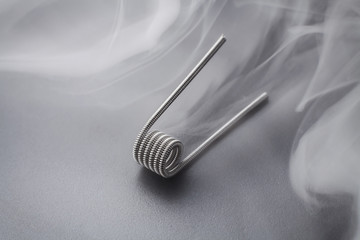 Clapton coil for vaping on a black background smoke