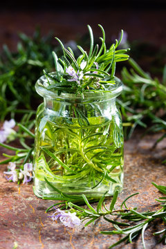 Rosemary essential oil jar glass bottle and branches of plant