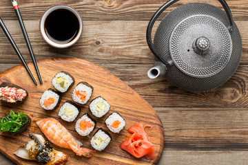 Top view sushi set, teapot and black sticks