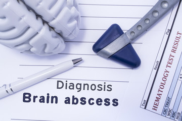 Diagnosis Brain Abscess. Figure brain, neurological hammer, printed on a paper blood test and written diagnosis of Brain Abscess in the medical form is lying on the table in the neurologist cabinet