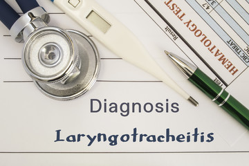Diagnosis Laryngotracheitis. Stethoscope, electronic thermometer, patient blood test results lying on medical history, which is written diagnosis Laryngotracheitis. Concept for internal medicine, ENT