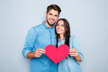 Young happy couple in love holding red paper heart