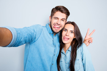 Funny couple showing tongues and gesturing v-sign while making s