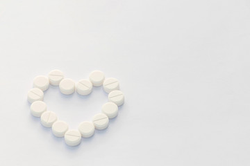 Abstract soft focus of the heart tablets of the pill with the white copy space background.