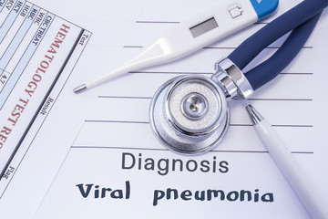 Diagnosis of viral pneumonia. Stethoscope, electronic thermometer, common blood test results are on medical form, which indicated diagnosis of viral pneumonia. Concept for internal medicine physician
