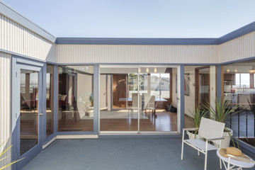 Sliding glass doors opening to rear courtyard of contemporary home.