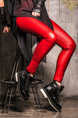 Girls legs in red leggings on gray background