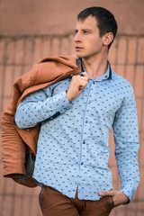 Cool fashion man in blue shirt standing and looking away.