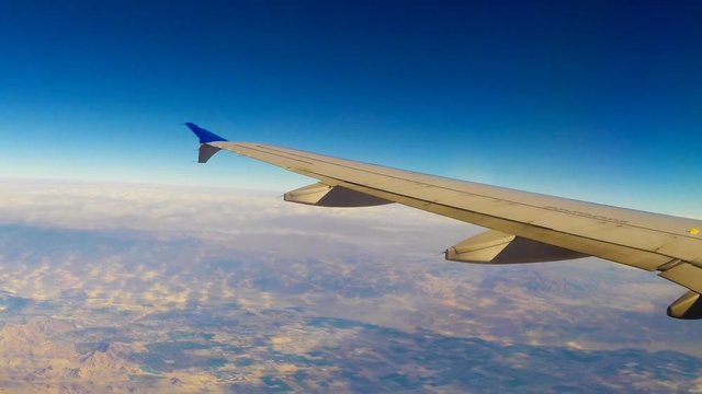 A view out the window of an airplane shows the baron desert 30,000 feet below.
