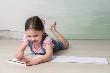 Naklejka premium little girl drawing watercolors 