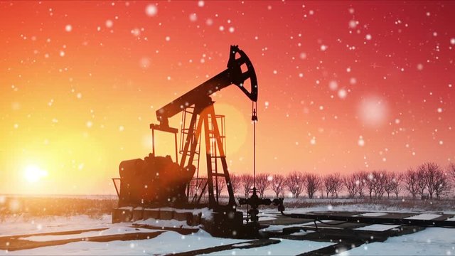 Oil field pumpjack silhouette with setting sun. Lens Flare.
