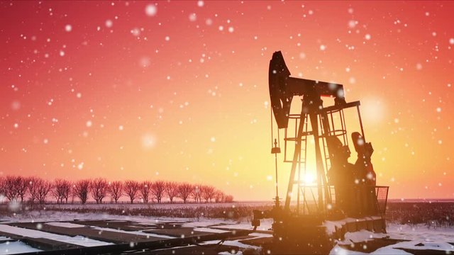 Oil field pumpjack silhouette with setting sun. Lens Flare.