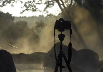 Silhouette of DSLR camera with sea at sunrise, Photo at morning time concept