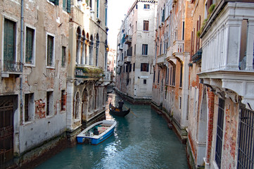 Fototapeta na wymiar Venice side canal of one moored boat and a gondla in it