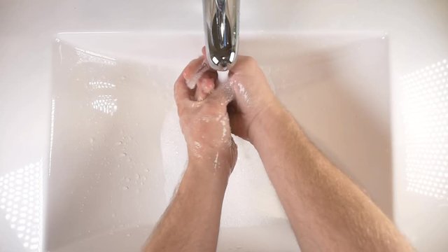 Washing hands in sink with soap to clean for good hygiene