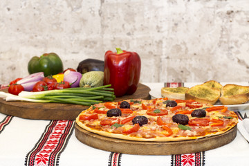 Tasty pizza with vegetables, basil, olives, tomatoes, green pepper.