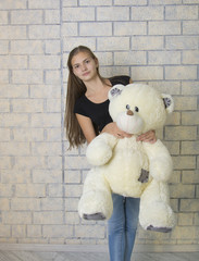 Young girls with toy bears, bricks background