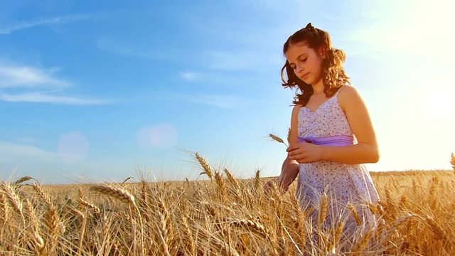 Little girl playing in the wheat field at sunset.Slow motion,high speed camera