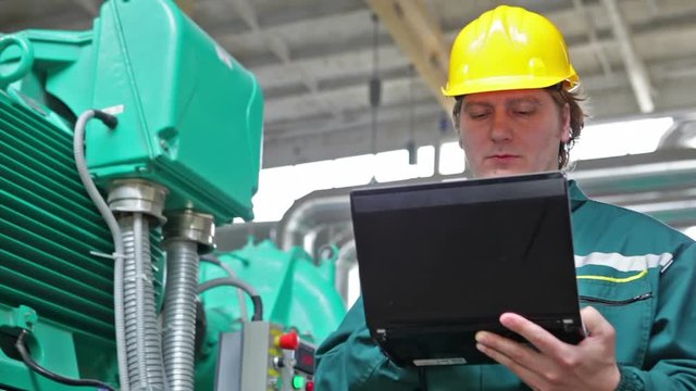 Industrial worker with notebook working in power plant