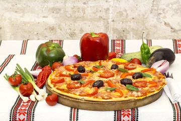 Tasty pizza with vegetables, basil, olives, tomatoes, green pepper.