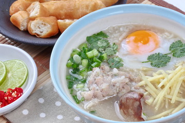 Close up of rice porridge with mined pork and chicken lever served with side dish as Patongko (deep-fried dough stick) and spicy sour filling.