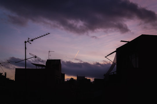 Lilac sunset and many silhouettes of roofs with antennas, Barcel