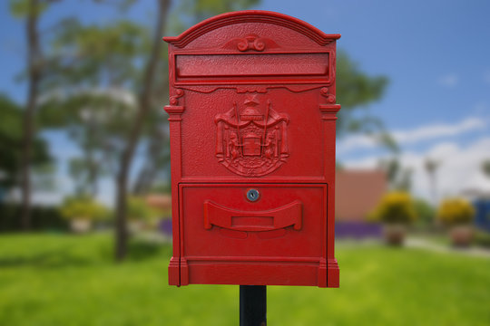 Big red  mailbox isolate on park background.