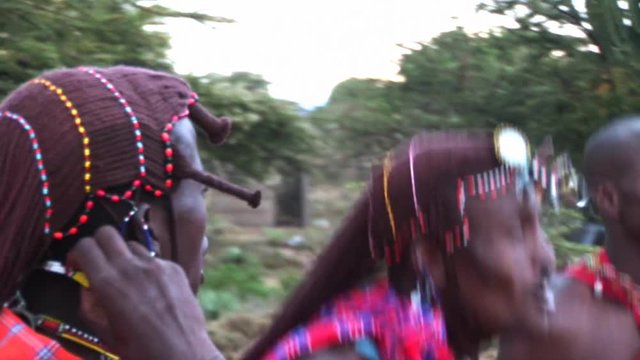 Masai warriors in traditional clothing, play and sing in the twilight after sunset. It is evident due to poor light but the sun is stored absolute authenticity of Masai life.