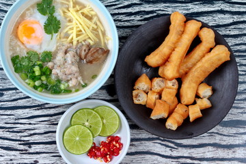 Rice porridge with mined pork and chicken lever served with side dish as Patongko (deep-fried dough stick) and spicy sour filling.