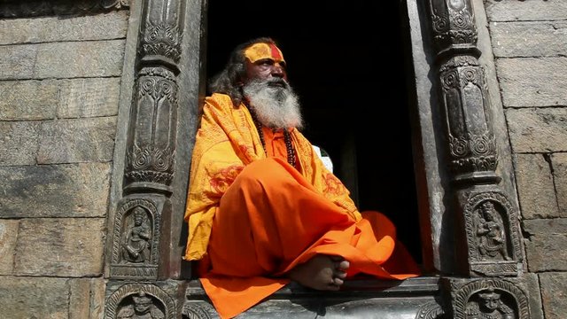 Portrait of Holy Sadhu man with long beard and traditional face paint in Pashupatinath Temple, Kathamandu, Nepal.