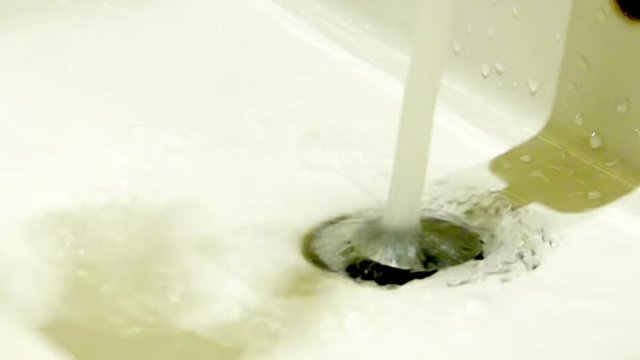 Water leak in the white sink, close up