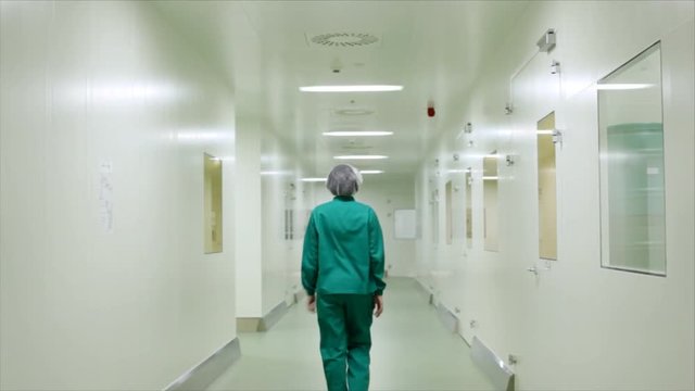 An empty hallway in the hospital and rear view of medical worker