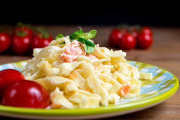 close-up of plate of pasta and smoked salmon with tomato