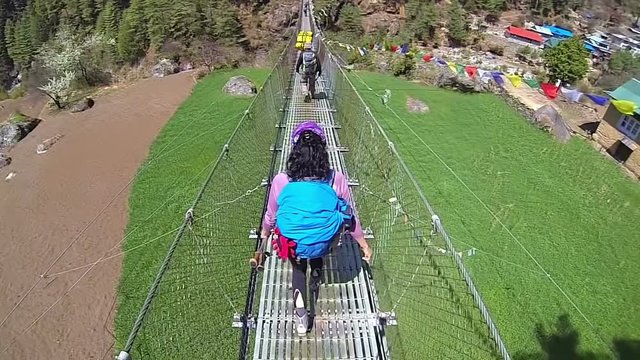 Rear view of female mountaineer on suspension bridge.High speed camera,slow motion