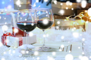 Glasses of red wine on blurred Christmas interior background. Christmas celebration concept.