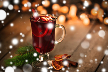 Glass of delicious Christmas mulled wine, closeup. Snowy effect, Christmas concept.