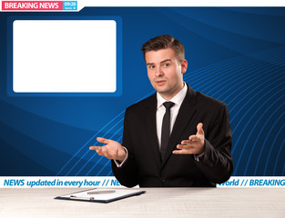 Television reporter telling breaking news at his studio desk wit