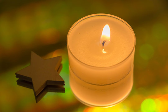 Kerzenlicht und ein Stern mit einem irisierenden Hintergrund



