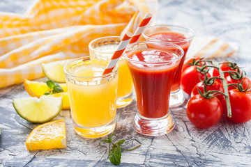 orange and tomato juice in glasses on a table, selective focus