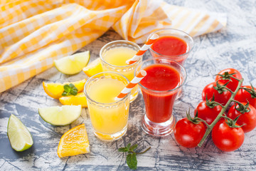 orange and tomato juice in glasses on a table, selective focus