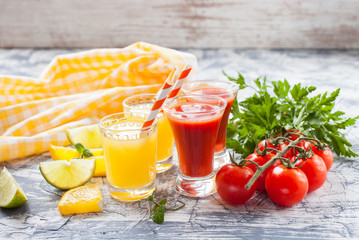 orange and tomato juice in glasses on a table, selective focus