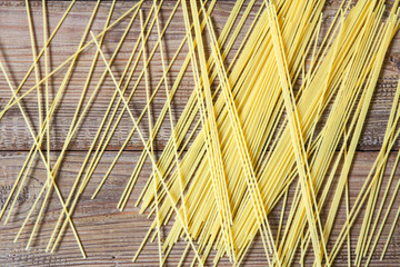 Pasta or spaghetti on brown wooden background. Top view