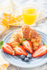 croissant and strawberry in a plate on a table, selective focus