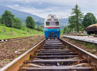 Fototapeta premium Old train on the railroad tracks on railway station in Carpathians