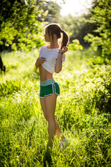 Naklejka na ściany i meble Beautiful young brunette girl doing sport outdoors in summer