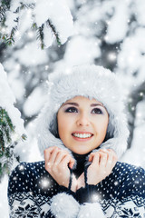 Portrait of a woman in a winter hat on a snow background