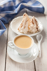 coffee and cakes of meringue on a table, selective focus